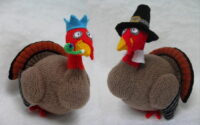 Knitted toys of turkeys dressed in pilgrim fathers outfits