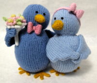 knitted toys of two birds looking romantically at each other