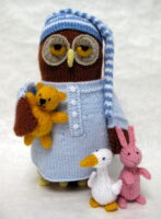 a knitted toy owl ready for bed in a night shirt