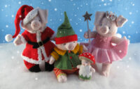 knitted toys of pigs dressed in Christmas costumes