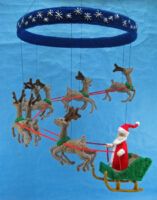 knitted mobile of Santa on his sleigh being pulled by his reindeer