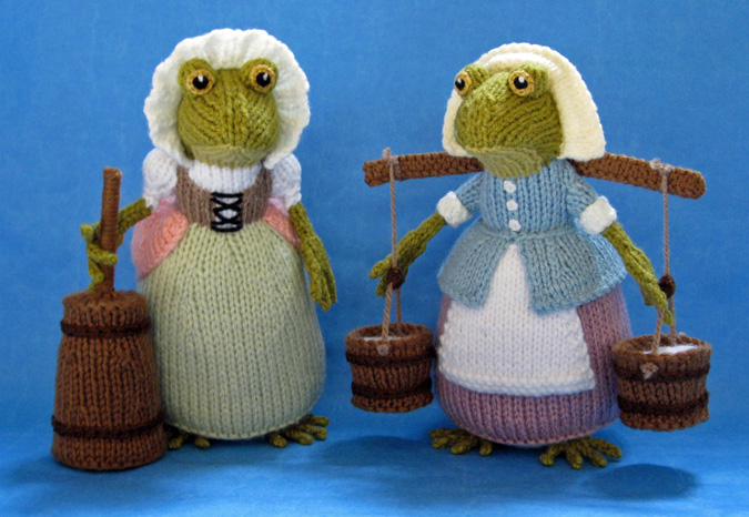 knitted toys of 2 frogs dressed as village maids