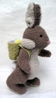 Knitted toy of the Easter bunny carrying a sack of eggs