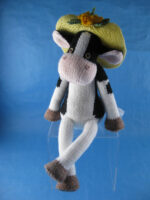 knitted toy of a holstein cow wearing a straw hat