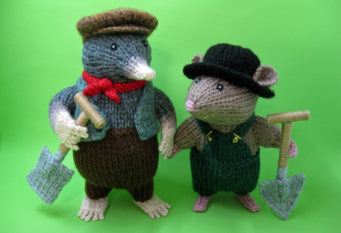 knitted toys of two moles dressed in workman's clothes