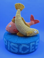 knitted toy of 2 fish on a plinth labelled Pisces