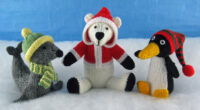 knitted toys of a seal, penguin and polar bear with wooly hats on